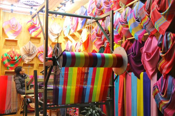 Cloths dyed in flamboyant colors are made into scarves for sale at stores in Lijiang. (Photo: CRIENGLISH.com/Zhang Linruo)