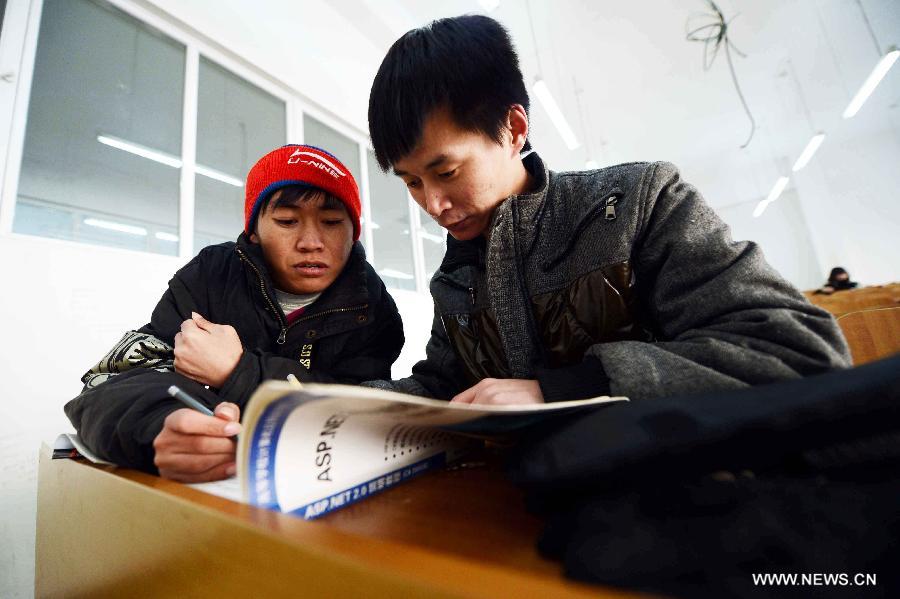 Wang Junsheng (R) studies with his disabled classmate Jiang Jian at school in Harbin, capital of northeast China's Heilongjiang Province, Dec. 19, 2012.