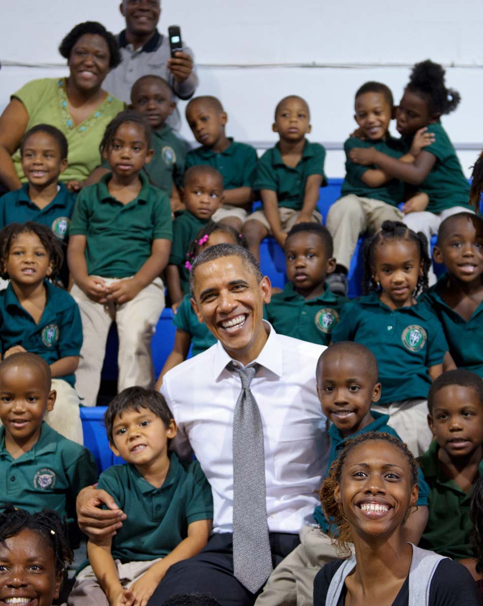 U.S. president Barack Obama takes photos with a group of pupils in Delray Beach, Florida, U.S. , Oct. 23, 2012. However, the focus of the whole picture was on the boy in the right corner who was kissing the girl next to him and hugged happily together.(Xinhua/AFP)