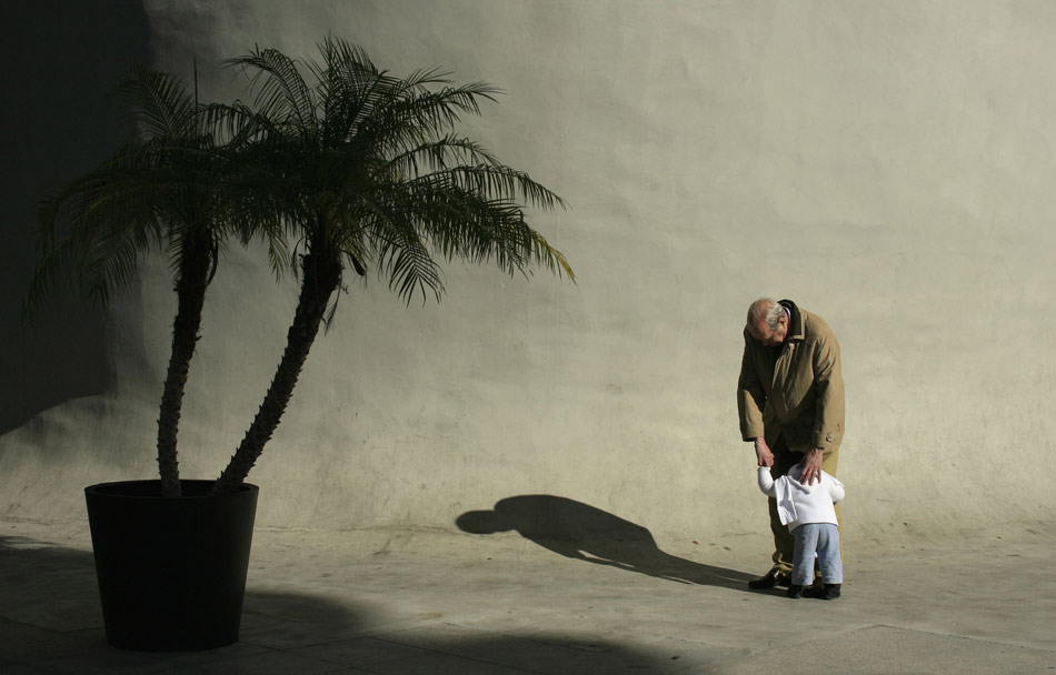 An old man hugs a little boy in Seville, Spain, Jan. 18, 2012.(Xinhua/Reuters)