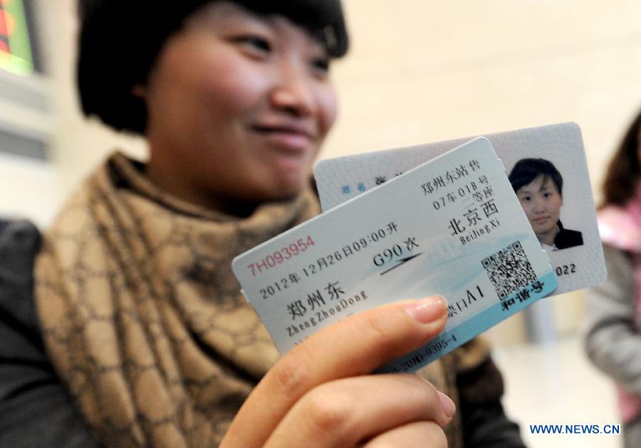 A woman buys the first ticket of a high-speed train from Zhengzhou to China's capital Beijing sold at the Zhengzhou East Railway Station in Zhengzhou, capital of central China's Henan Province, Dec. 20, 2012. 