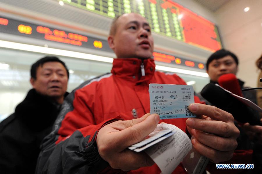 A man buys a ticket of a high-speed train from Zhengzhou to China's capital Beijing at the Zhengzhou East Railway Station in Zhengzhou, capital of central China's Henan Province, Dec. 20, 2012.