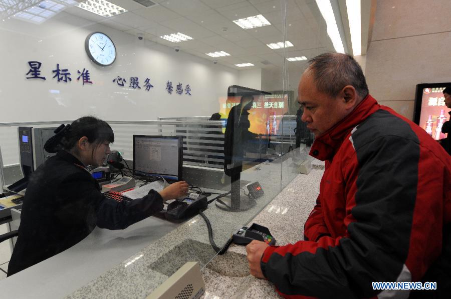 A man buys a ticket of a high-speed train from Zhengzhou to China's capital Beijing at the Zhengzhou East Railway Station in Zhengzhou, capital of central China's Henan Province, Dec. 20, 2012. 