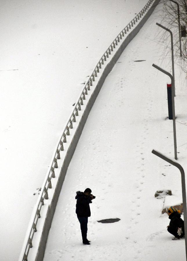 A citizen takes photos at a snow-covered park in Taiyuan, capital of north China's Shanxi Province, Dec. 20, 2012. Most parts of Shanxi witnessed a heavy snow on Thursday. (Xinhua/Yan Guozheng)  