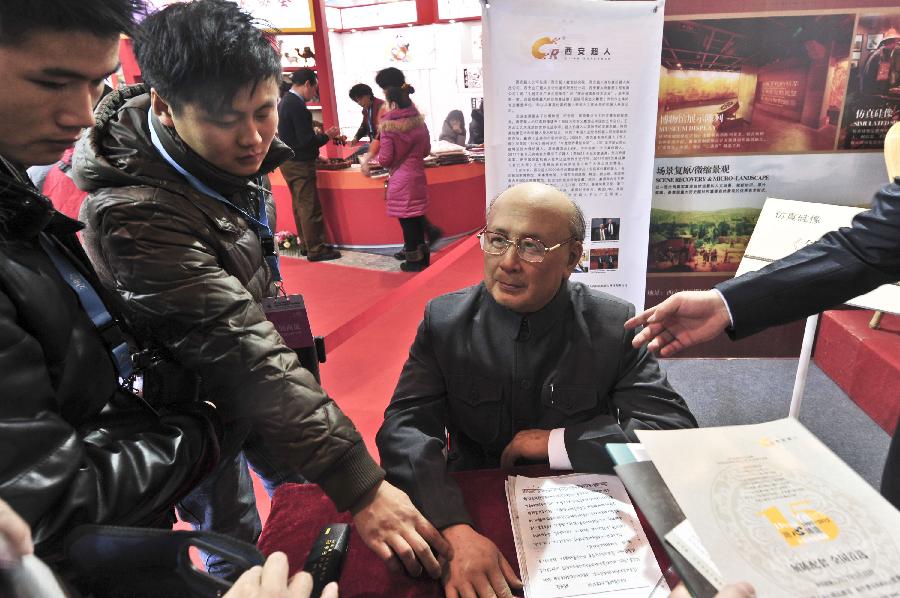Visitors appreciate a high-imitation silicon figure of Qian Xuesen during the 7th China (Beijing) International Cultural and Creative Industry Expo (ICCIE) in Beijing, capital of China, Dec, 20, 2012. The expo, which opened here on Thursday, attracted some 50 delegations from 6 international organizations and 15 countries and regions. (Xinhua/Wang Jingsheng) 