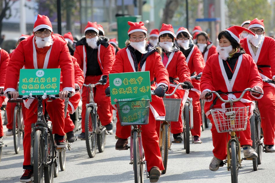 The middle school students dress as Santa Claus to promote the concept of low-carbon environment to public in Nantong of Jiangsu province on Dec. 19, 2012. (Xinhua/Ding Xiaochun)