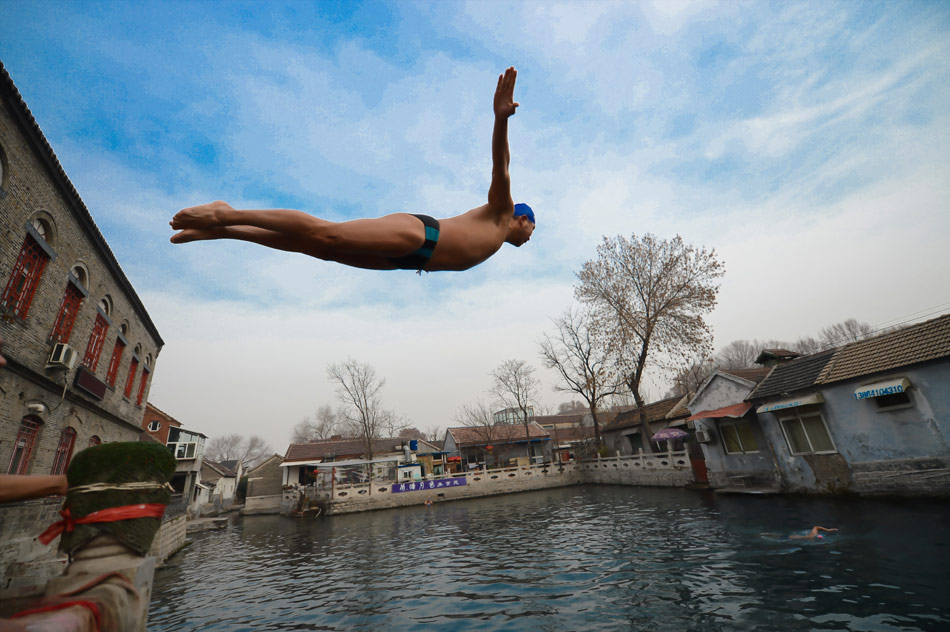 A winter swimming enthusiast jumps into the water in Jinan on Dec.19 2012. (Xinhua/Guo Xulei)