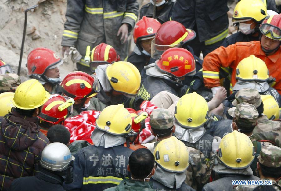 Rescuers carry out a woman trapped in a collapsed residential building in Ningbo, east China's Zhejiang Province, Dec. 17, 2012. (Xinhua/Cui Xinyu)