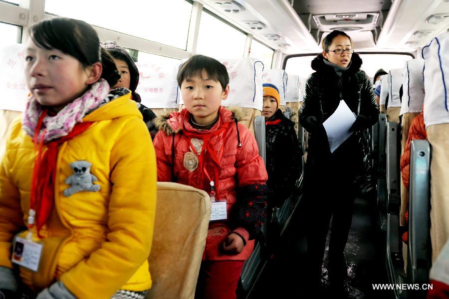 A teacher organizes students on a school bus in Gaolan county, Lanzhou city of northwest China's Gansu province, Dec. 21, 2012. According to local educational authorities, a total of 3,117 lines of school buses were put to use, providing service for more than 300,000 boarders of compulsory students. (Xinhua/Nie Jianjiang) 