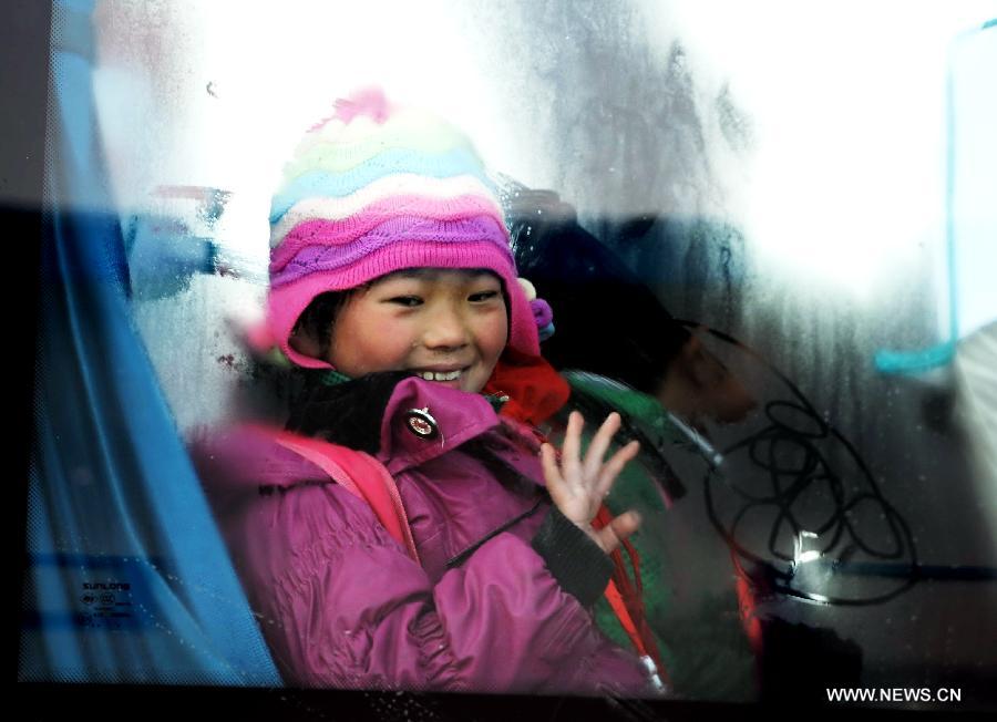 A girl student waves on a school bus in Gaolan county, Lanzhou city of northwest China's Gansu province, Dec. 21, 2012. According to local educational authorities, a total of 3,117 lines of school buses were put to use, providing service for more than 300,000 boarders of compulsory students. (Xinhua/Nie Jianjiang) 