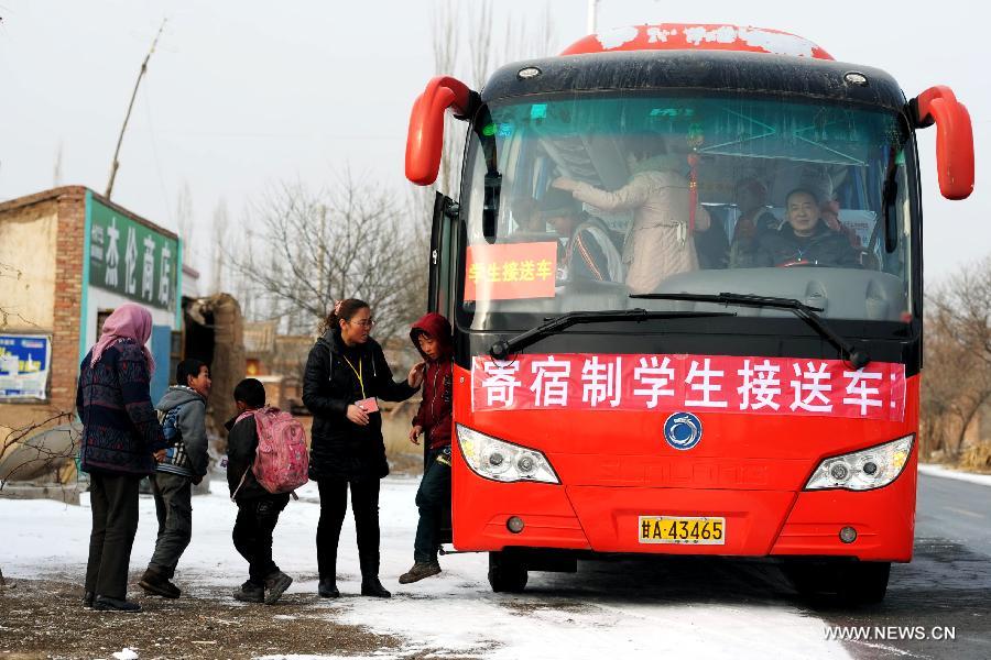 Students get off a school bus in Gaolan county, Lanzhou city of northwest China's Gansu province, Dec. 21, 2012. According to local educational authorities, a total of 3,117 lines of school buses were put to use, providing service for more than 300,000 boarders of compulsory students. (Xinhua/Nie Jianjiang) 