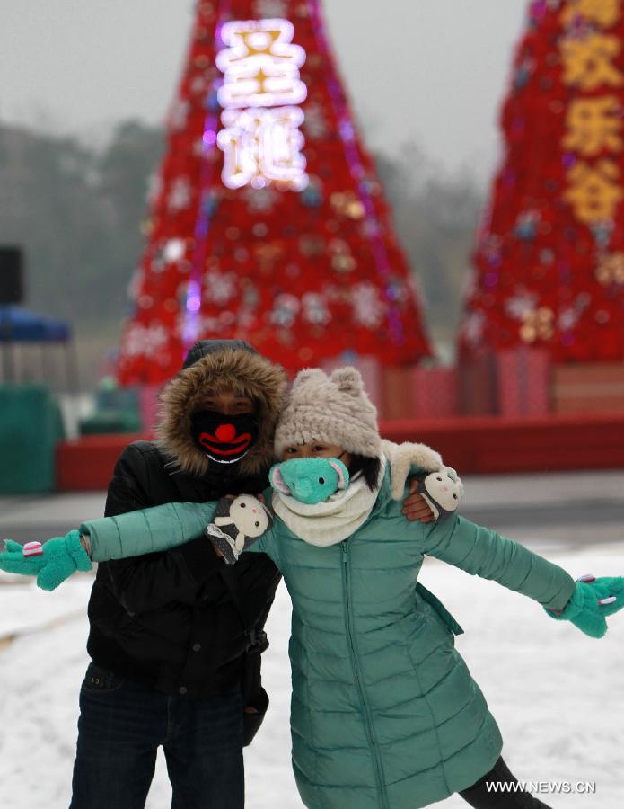 Tourists pose for photo in front of Christmas tress in Happy Valley, an entertainment park, in east China's Shanghai, Dec. 21, 2012. A Christmas Carnival held by the entertainment park kicked off on Friday. (Xinhua/Pei Xin)  