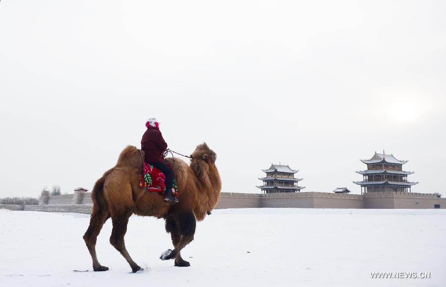 A woman rides a camel beside the Jiayu Pass after snowfall in Jiayuguan City, northwest China's Gansu Province, Dec. 21, 2012. (Xinhua/Zhang Meng) 
