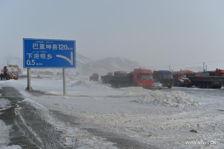 Photo taken on Dec. 20, 2012 shows the trapped vehicles parking on safe place after being transferred from blizzard-hit S303 road in Xialaoba Township of Kazak Autonomous County of Barkol in northwest China's Xinjiang Uygur Autonomous Region. More than 800 vehicles and 1,000 people were trapped on roads amid a blizzard in the county and rescuers have transferred most vehicles and people to safe place. (Xinhua/Zhang Jiangang)  
