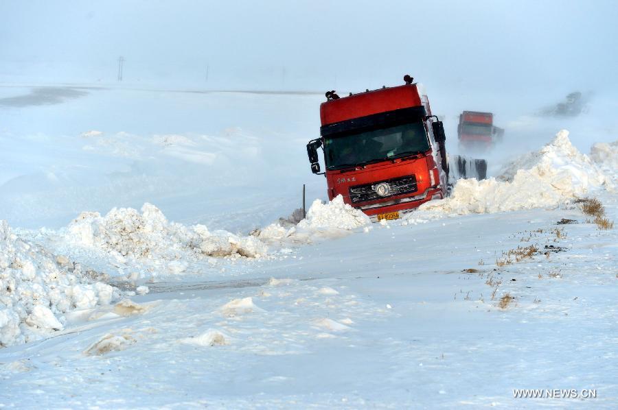 Photo taken on Dec. 20, 2012 shows a trapped truck in the snow on the blizzard-hit S303 road in Kazak Autonomous County of Barkol in northwest China's Xinjiang Uygur Autonomous Region. More than 800 vehicles and 1,000 people were trapped on roads amid a blizzard in the county and rescuers have transferred most vehicles and people to safe place. (Xinhua/Zhang Jiangang) 