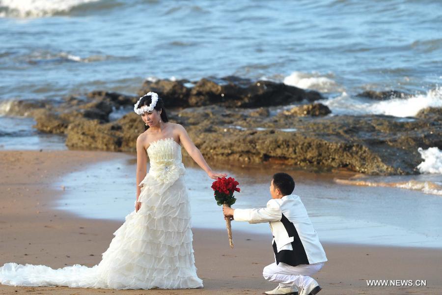 A newly-married couple take wedding photos on the beach in Haikou, capital of south China's Hainan Province, Dec. 21, 2012. Thursday marks the Dongzhi Festival, or Winter Solstice. Contrary to people in north China who are expected to welcome the coldest winter days, people in Hainan still enjoy the warm climate. (Xinhua/Zhao Yingquan)
