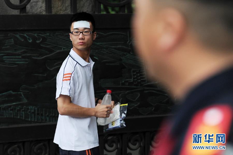 An examinee with a cooling gel sheet on his forehead is about to enter an examination room on June 7, 2012. (Xinhua/Ju Huanzong)