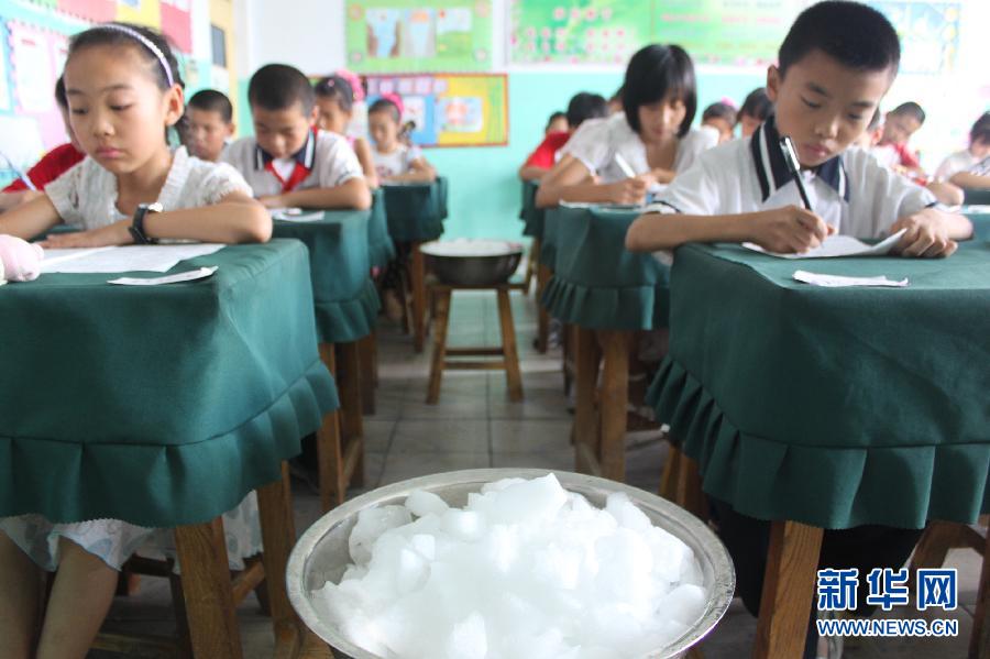 Elementary students take the final exam in a classroom equipped with ice to cool down in Boxing County, Binzhou, Shandong Province on July 3, 2012. The highest temperature reached 35 Celsius degree that day. (Xinhua/Chen Bin)