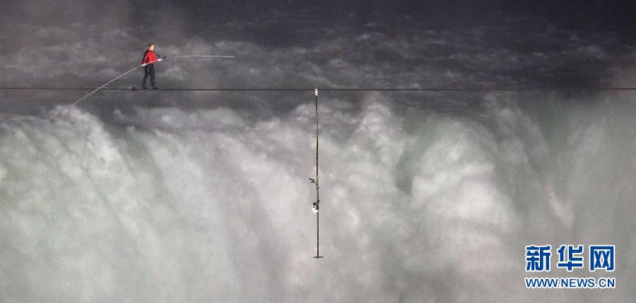 Nik Wallenda completes a walk on a tightrope across the Niagara Fallson on June 15, 2012. He is a seventh-generation member of The Flying Wallendas family and is the first person who crossed Niagara Falls by walking on tightrope with length of 500 meter. (Xinhua/AFP Photo)