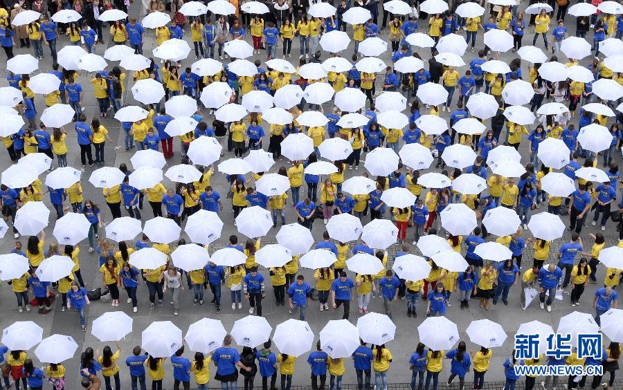 High school graduates dance with umbrellas in a city square in Sarajevo, Bosnia, on May 18, 2012. Over 32,000 high-school graduates from 70 cities in 10 countries attempt to break a Guinness world record in synchronized quadrille dancing. (Xinhua/AP)