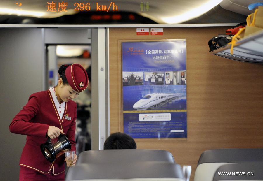 A stewardess provides service on G80 express train during a trip to Beijing, capital of China, Dec. 22, 2012.(Xinhua/Chen Yehua) 