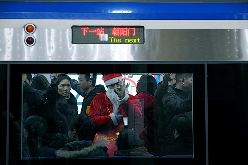 Photo "Subway Santa" shows the subway crowd in a Christmassy atmosphere. Christmas is one of the most popular Western holidays in China and is welcomed by more and more Chinese. (China.org.cn/Francisco Little)