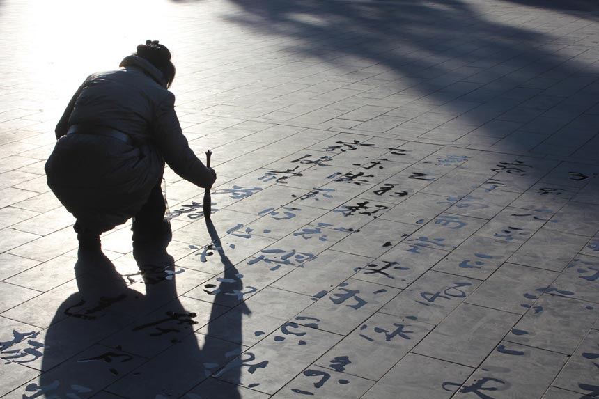 Photo "Shadows" shows a woman working on her calligraphy at the Temple of Heaven. A lot of people do this across Beijing's parks, creating both a special scenery as well as atmosphere. (China.org.cn/Guillet Raphael)