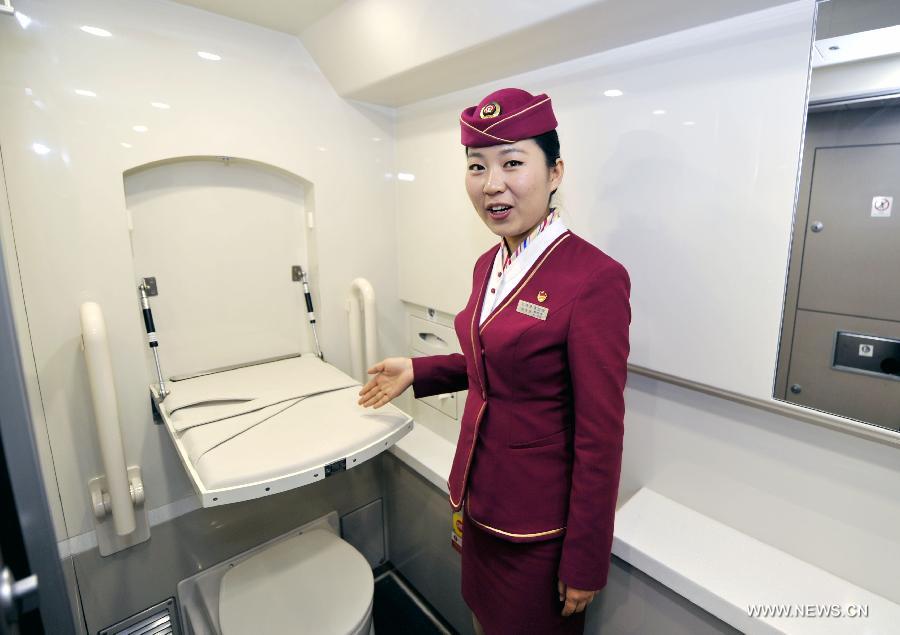 A stewardess shows the diaper changing table in a toilet of G80 express train during a trip to Beijing, capital of China, Dec. 22, 2012.