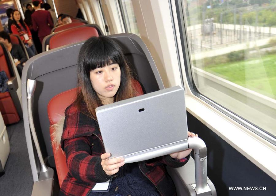 A passenger watches television in a business class carriage of G80 express train during a trip to Beijing, capital of China, Dec. 22, 2012.