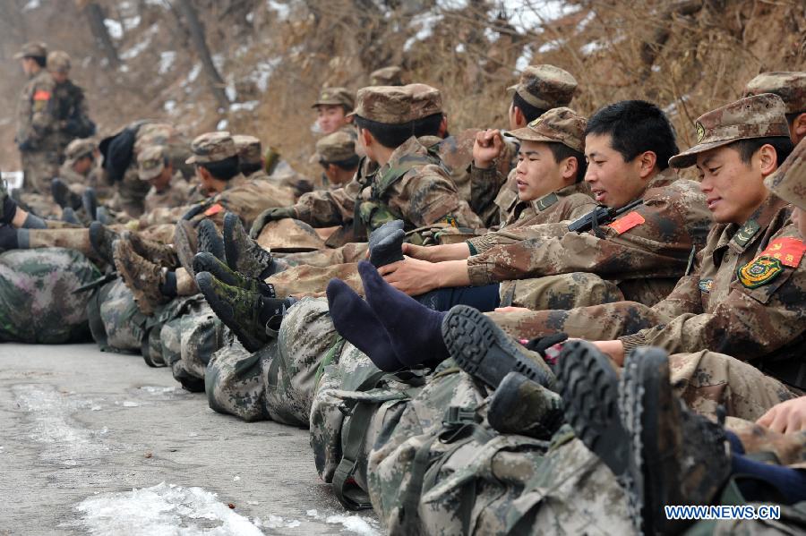 Soldiers have a rest on the route of march during a military training in central China's Henan Province, Dec. 19, 2012. Thousands of soldiers went through harsh environment as they participated in the military training here. (Xinhua/Shen Dongdong)  