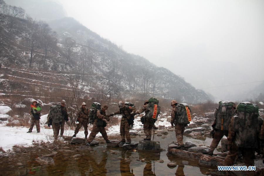 Soldiers try to get through a brook during a military training in central China's Henan Province, Dec. 19, 2012. Thousands of soldiers went through harsh environment as they participated in the military training here. (Xinhua/Shen Dongdong)  