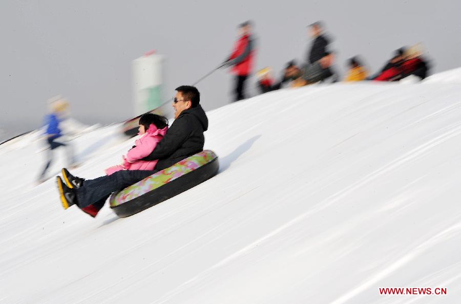 A girl plays with her father in a ski resort in Yinchuan City, capital of northwest China's Ningxia Hui Autonomous Region, Dec. 23, 2012. (Xinhua/Peng Zhaozhi) 