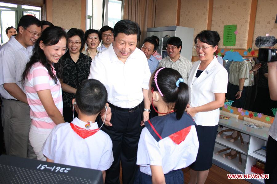 File photo taken in September 2007 shows Xi Jinping (C), then secretary of the Shanghai Municipal Committee of the Communist Party of China (CPC), talks with hearing-impaired students at Qiyin School in Minhang District of east China's Shanghai. (Xinhua) 