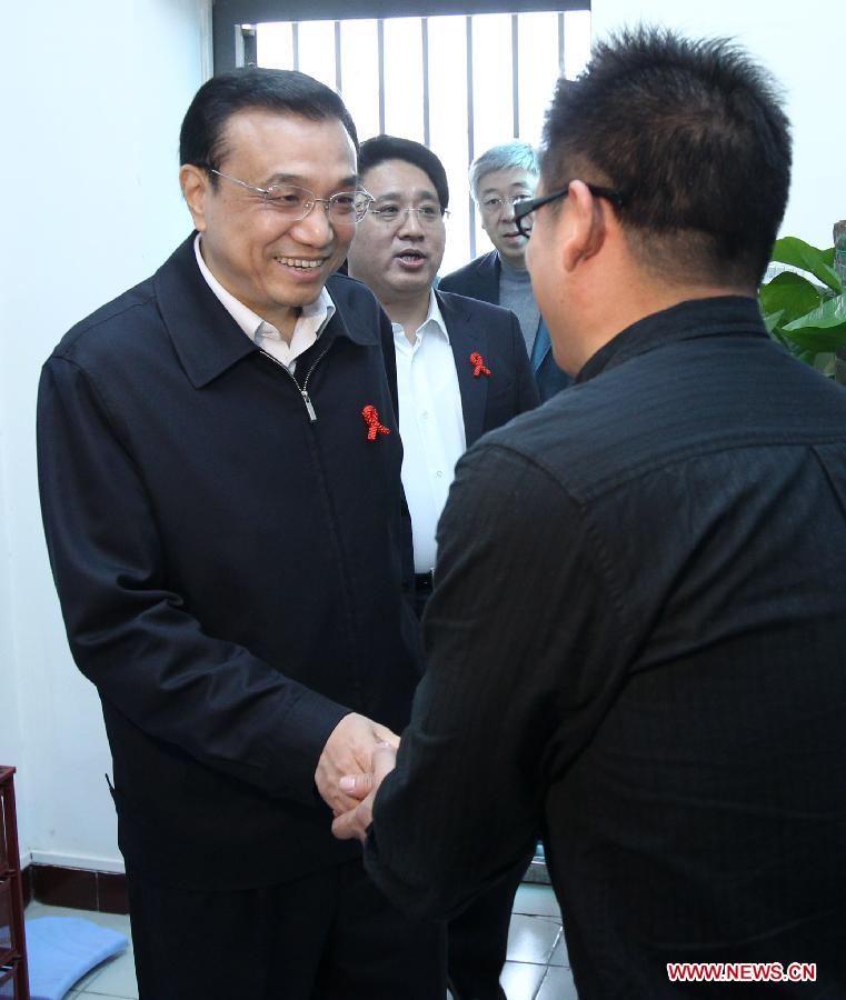 File photo taken on Nov. 18, 2011 shows Li Keqiang (L) shakes hands with an HIV carrier when he inspects AIDS prevention and treatment work in Beijing, capital of China. (Xinhua/Pang Xinglei) 