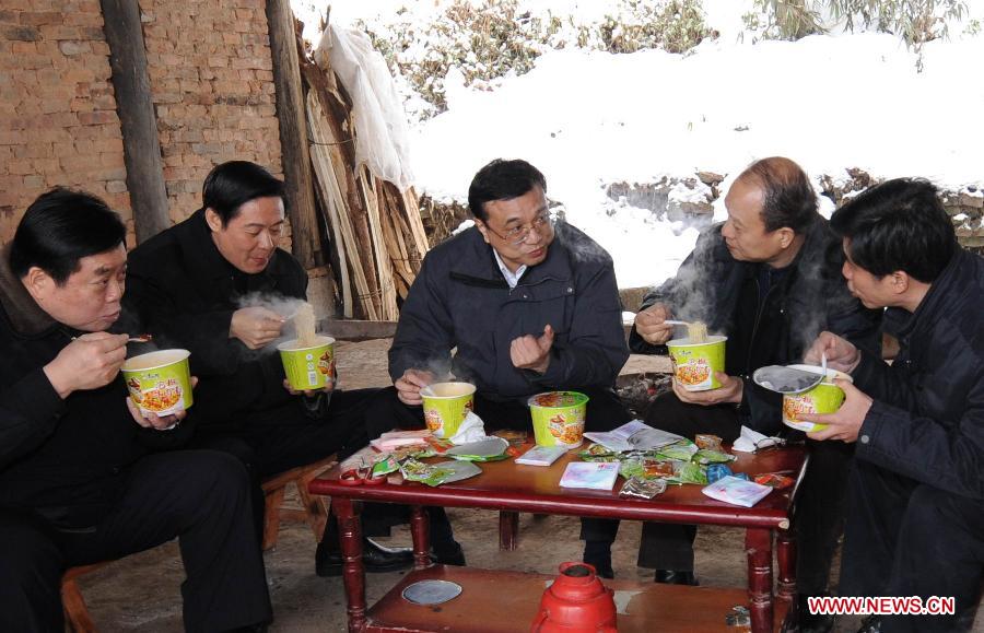 File photo taken on Jan. 31, 2008 shows Li Keqiang eats instant noodles with his colleagues as they talk about disaster relief work in the snowstorm-stricken Ziyun Village of Laojun Township of Xuanhan County in southwest China's Sichuan Province. (Xinhua/Li Xueren) 