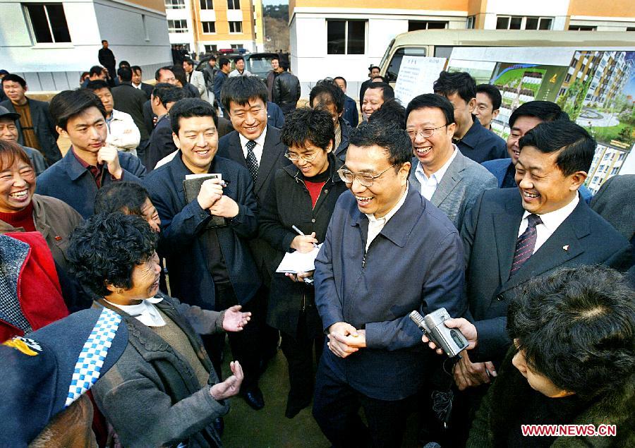 File photo taken on Nov. 3, 2005 shows Li Keqiang talks to people who moved to new houses from shanty town area in Fushun, northeast China's Liaoning Province. (Photo/Xinhua) 