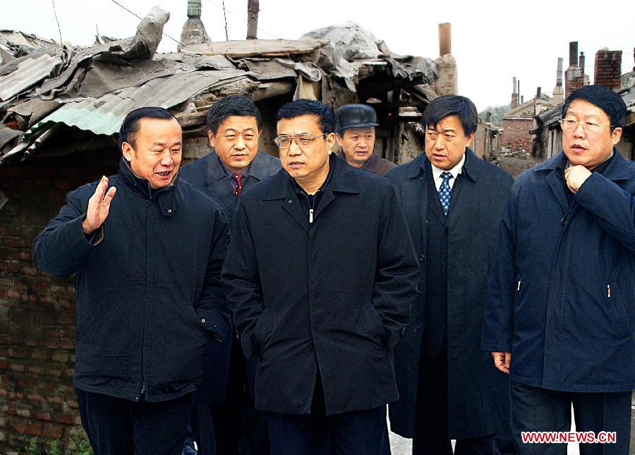 File photo taken on Dec. 26, 2004 shows Li Keqiang (3rd L), then secretary of Liaoning Provincial Committee of the Communist Party of China, inspects the Modigou shanty town area in Fushun, northeast China's Liaoning Province. (Photo/Xinhua) 