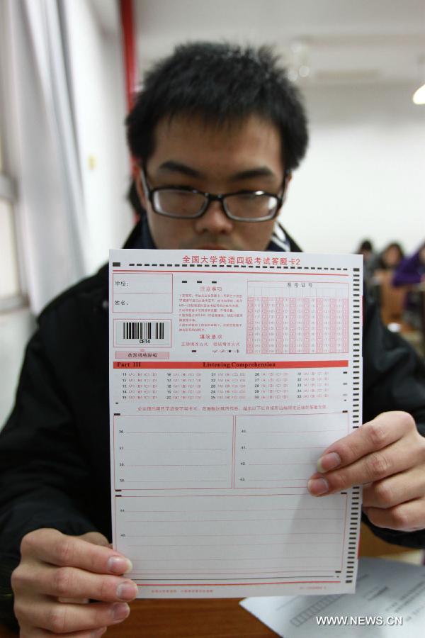 A candidate of National College English Test shows an answer card at Jiangsu University in Zhenjiang, east China's Jiangsu Province, Dec. 22, 2012.