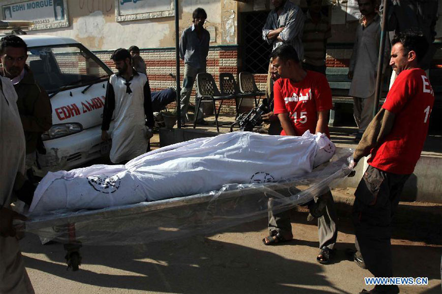 Pakistani rescuers carry a dead body of an illegal immigrant for identification, who were killed near the border with Iran, in southern Pakistani port city Karachi, on Dec. 23, 2012. Some unknown gunmen killed at least 10 people on Friday evening as they attacked a passenger vehicle in Pakistan's southwestern province of Baluchistan, local media reported. (Xinhua/Arshad) 