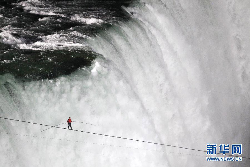 Nik Wallenda completes a walk on a tightrope across the Niagara Fallson on June 15, 2012. He is a seventh-generation member of The Flying Wallendas family and is the first person who crossed Niagara Falls by walking on tightrope with length of 500 meters. (Xinhua/AFP Photo)