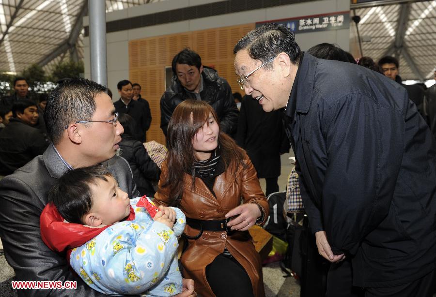 File photo taken on Feb. 11, 2010 shows Yu Zhengsheng (R) talks with passengers while he inspects the work for the Spring Festival travel rush in Shanghai South Station of east China's Shanghai Municipality. (Xinhua) 