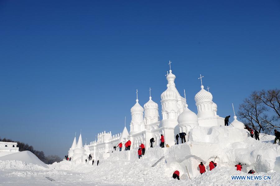 Workers shape a snow sculpture at Jingyuetan National Forest Park in Changchun, capital of northeast China's Jilin Province, Dec. 24, 2012. The "Jingyue Snow World", with numbers of snow sculptures, opened to tourists on Monday.(Xinhua/Zhang Nan)