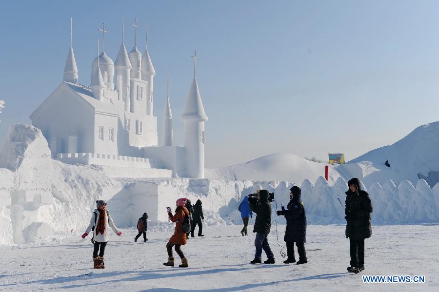 Visitors view a snow sculpture at Jingyuetan National Forest Park in Changchun, capital of northeast China's Jilin Province, Dec. 24, 2012. The "Jingyue Snow World", with numbers of snow sculptures, opened to tourists on Monday.(Xinhua/Zhang Nan)