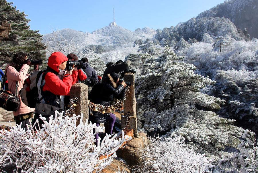 A visitor takes pictures of the rime scenery at the Huangshan Mountain scenic area in east China's Anhui Province, Dec. 23, 2012. (Xinhua/Shi Guangde) 