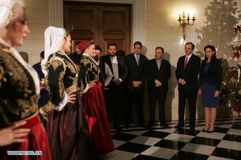 Members of cultural clubs, dressed in traditional costumes, perform for Greek Prime Minister Antonis Samaras(2nd R) at Maximos Mansion, central Athens, Greece, Dec. 24, 2012. On Christmas Eve, traditional carols are sung throughout Greece, giving a tone of optimism in a country struck by the economic crisis. (Xinhua/Marios Lolos)