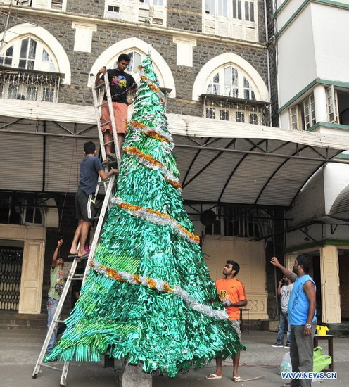 People prepare a Christmas tree outside a church to celebrate Christmas Day, in Mumbai, India, on Dec. 24, 2012. (Xinhua/Wang Ping)