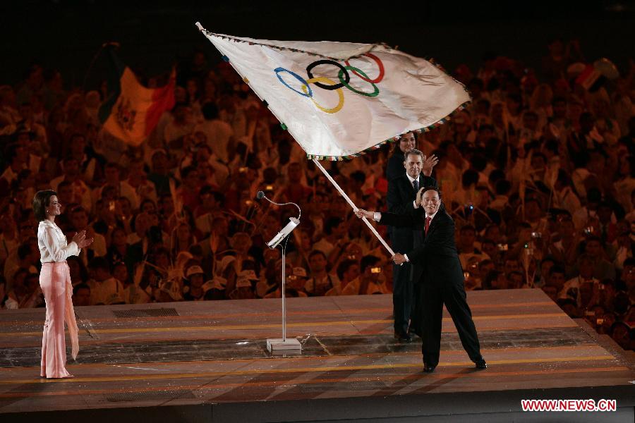 File photo taken on Aug. 30, 2004 shows Wang Qishan (R, front) takes the Olympic flag at the closing ceremony of the Athens Olympic Games. (Xinhua) 