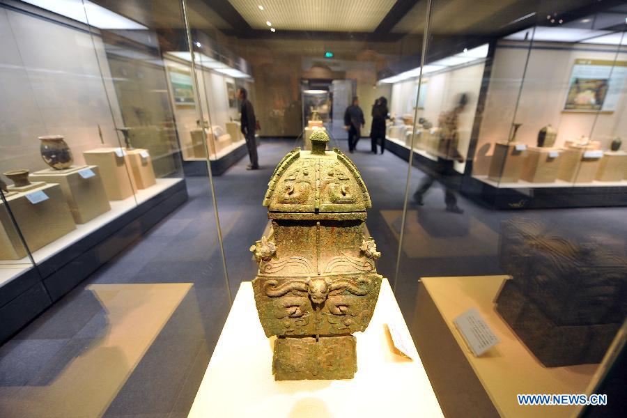 Visitors look at the exhibits at the Shanxi Museum in Taiyuan, capital of north China's Shanxi Province, Dec. 25, 2012. The "footprints of civilization" exhibition was held at the Shanxi Museum on Tuesday, showing some 300 items of antiques highlighting the achievements of the Archeology Institute of the Chinese Academy of Social Sciences. (Xinhua/Zhan Yan) 