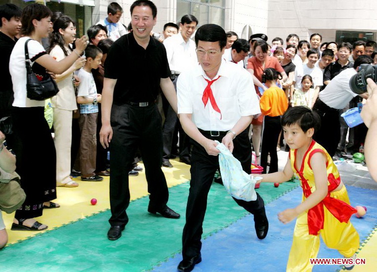 File photo taken on June 1, 2005 shows Zhang Gaoli (2nd R) plays games with a child while visiting children at Jinan Women and Children Activity Center in east China's Shandong Province. (Xinhua/Zi Binghui) 