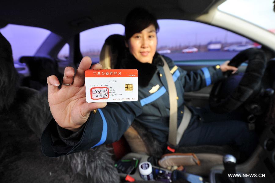 A woman shows her IC card pre-associated with the ETC system at the Yinchuan North Highway toll gate in Yinchuan, capital of northwest China's Ningxia Hui Autonomous Region, Dec. 25, 2012. (Xinhua/Peng Zhaozhi) 